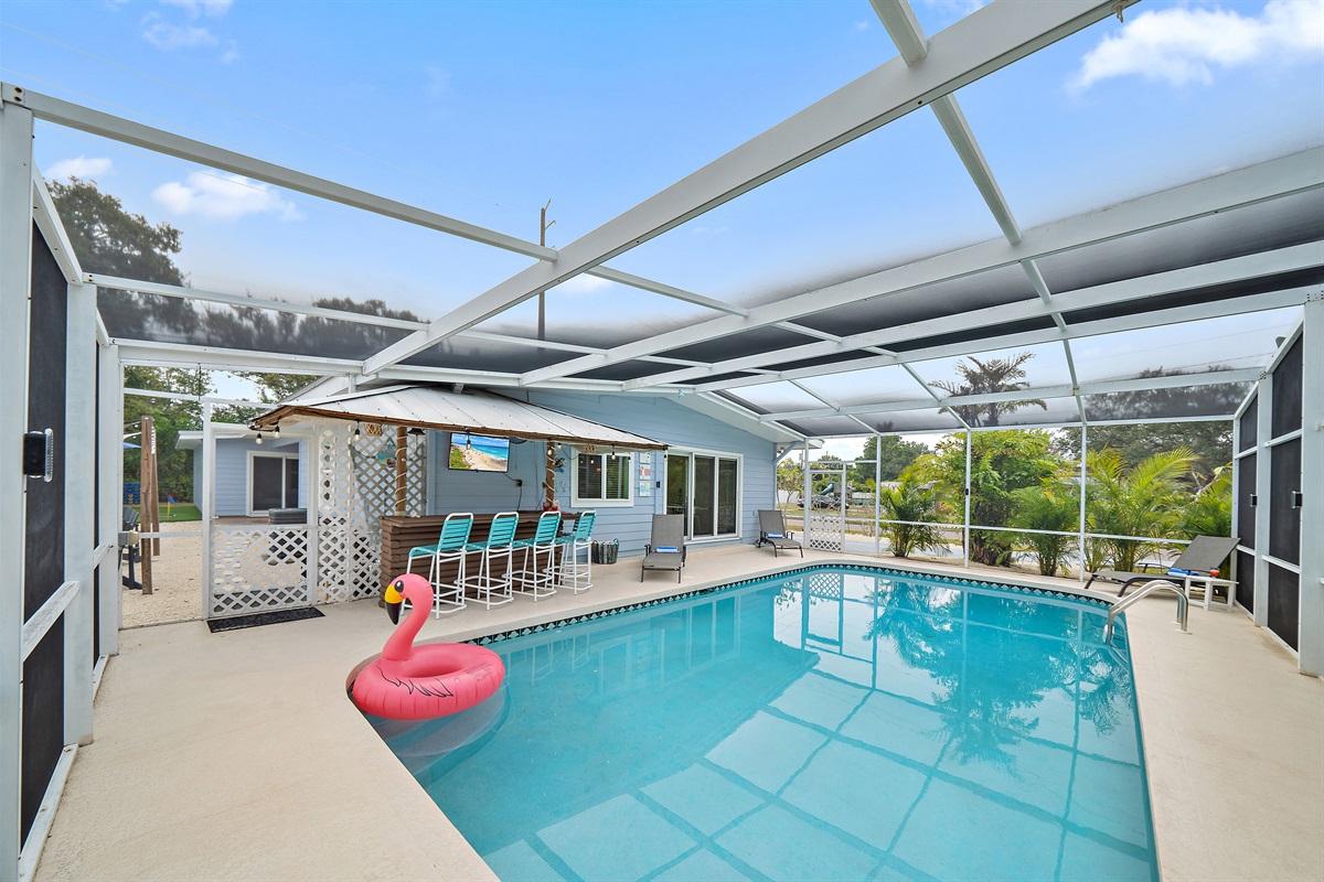 ☀️ Enjoy resort-style living with pool, tiki bar with TV, sun loungers, and a screened lanai.