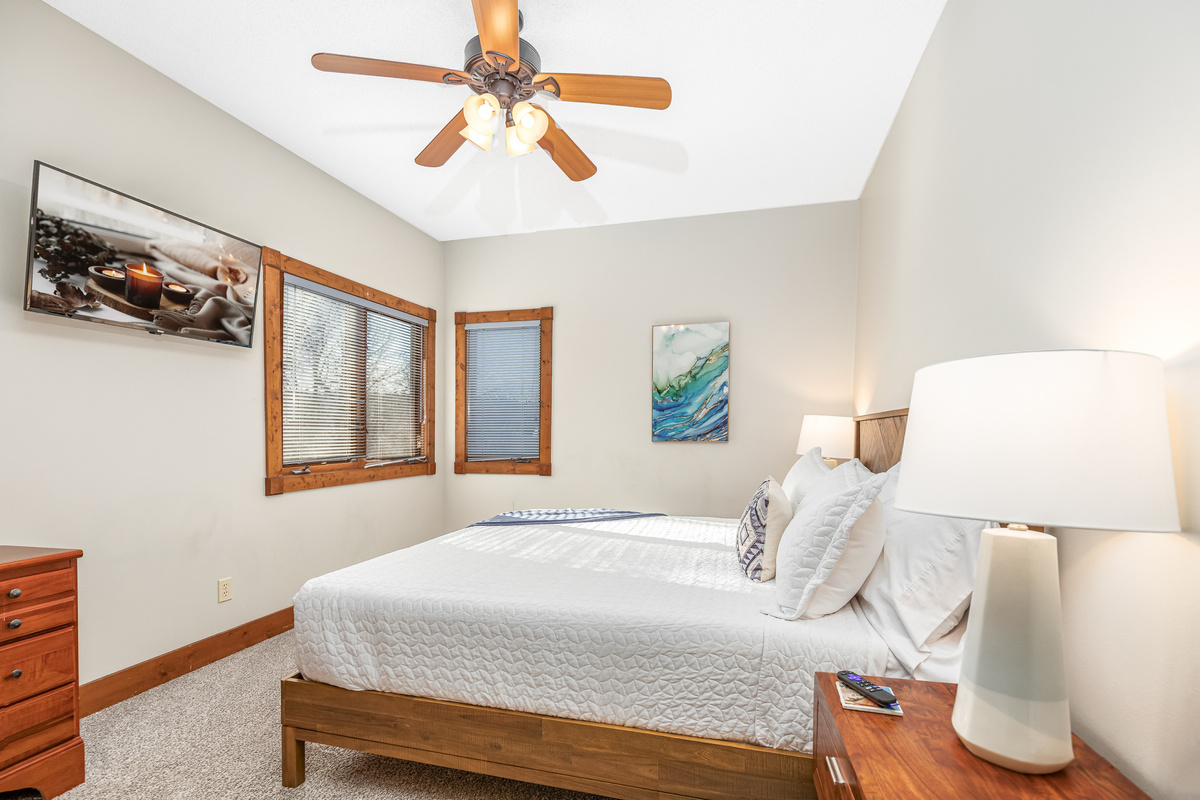 Bedroom 2 featuring a King bed and a Roku Smart TV, and a bathroom directly adjacent to the bedroom; one of two bedrooms located on the main floor.