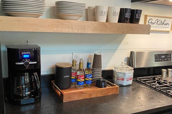 Complimentary coffee bar with to-go cups for day of checkout.