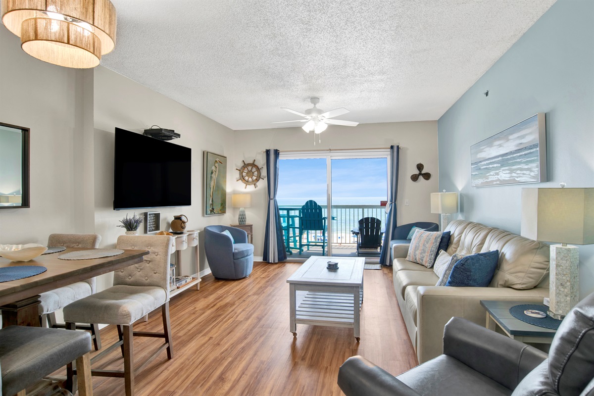 Living room with sleeper sofa, recliner, arm chair, ceiling fan, wall mounted Smart TV and a great Gulf and beach view 