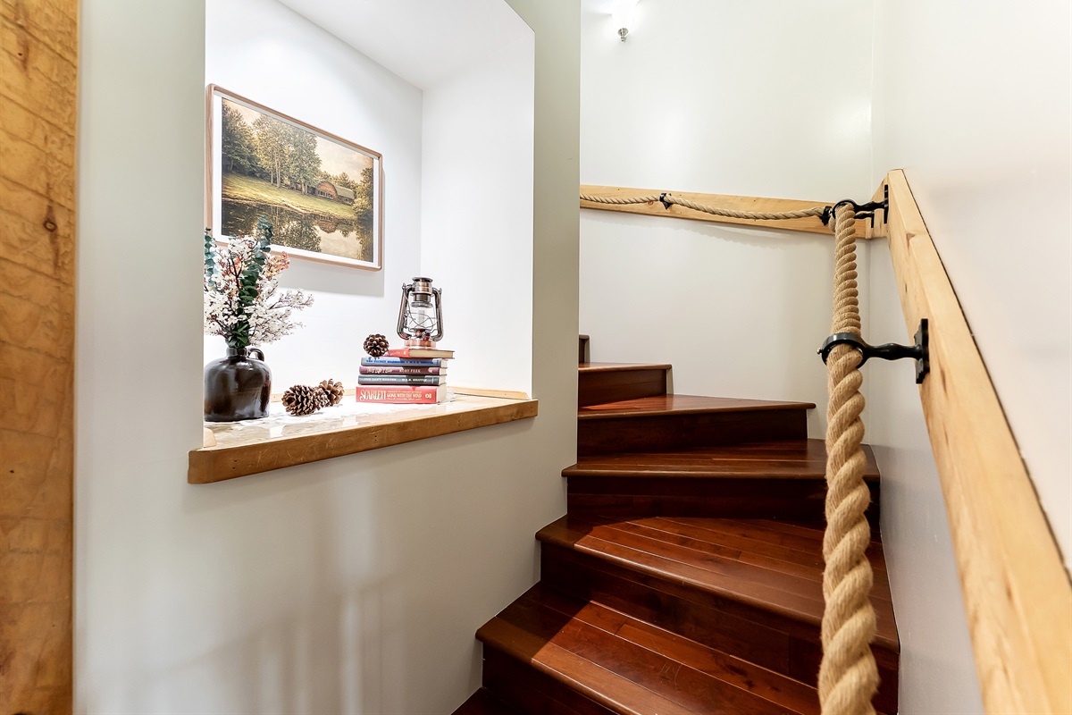 Stairs leading upstairs to the other 2 bedrooms, second living area and game room.
