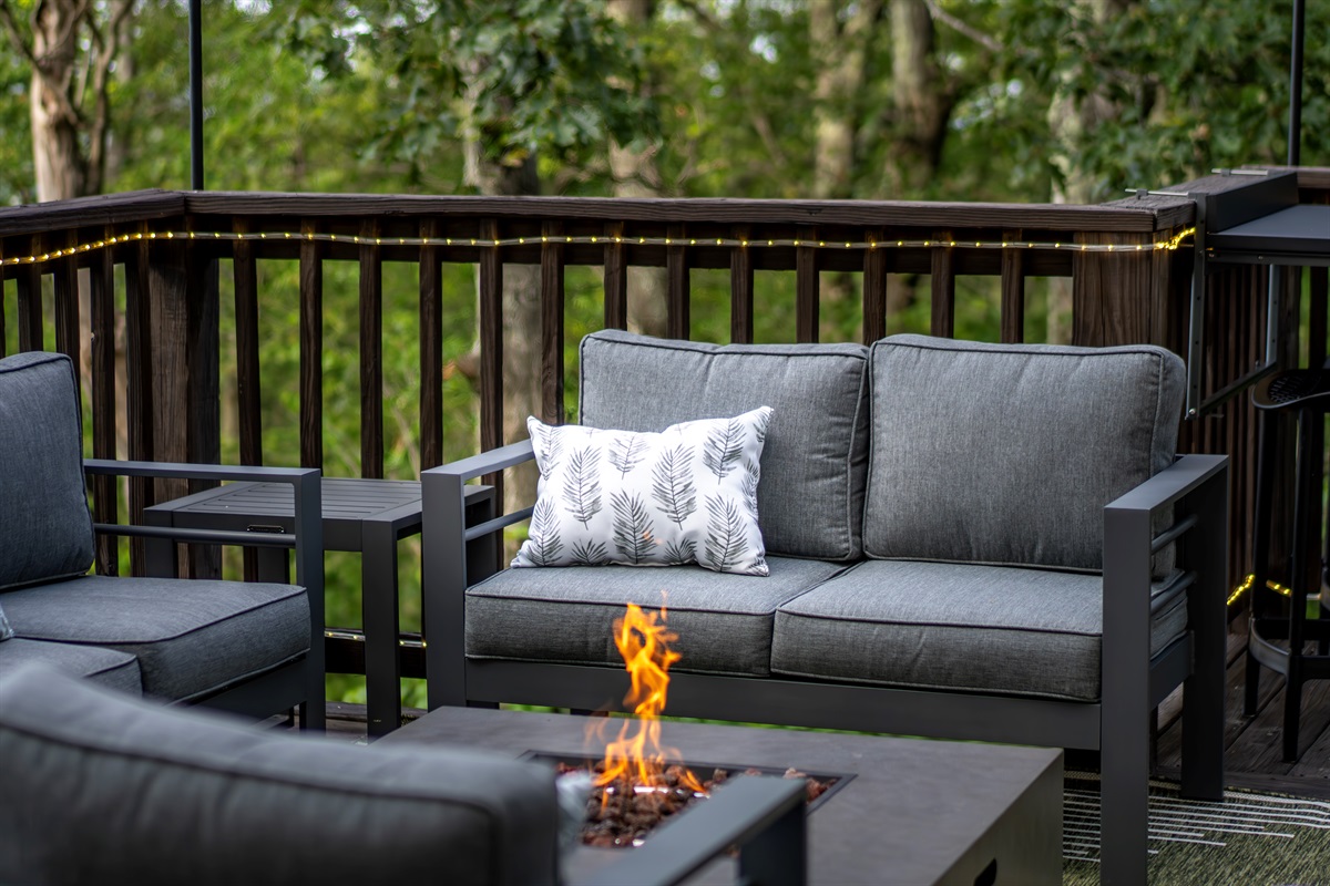 Pillows, firelight, and treetop views—this isn’t just a deck, it’s a designer-crafted escape for slow mornings or late-night laughs