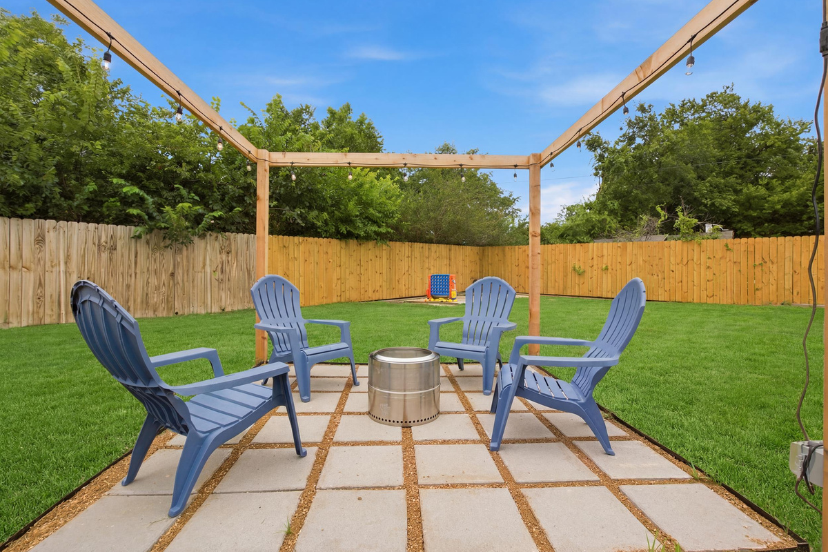 Blue Adirondack Chairs gathered around the Fire Pit under the Pergola. Cozy outdoor seating for s'mores, stargazing, and post-game recaps.
