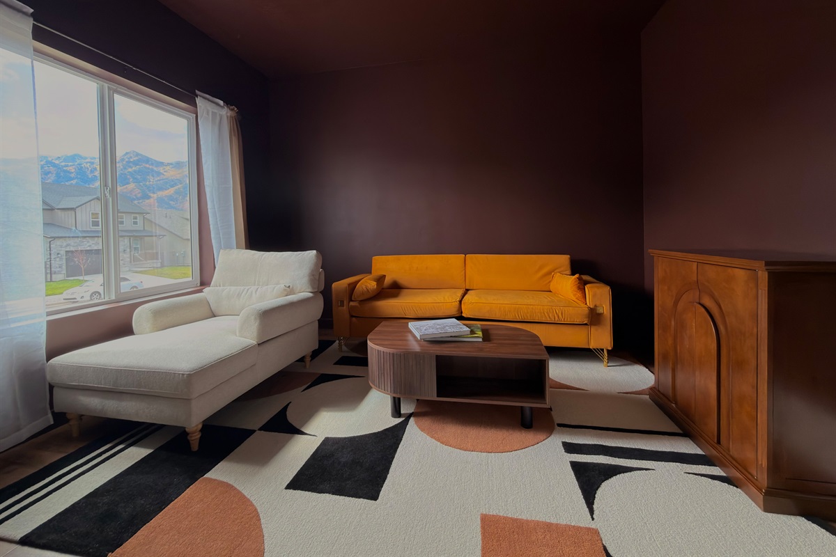 Chic, intimate den featuring plush seating and a rich color palette for relaxed conversation or quiet reflection.