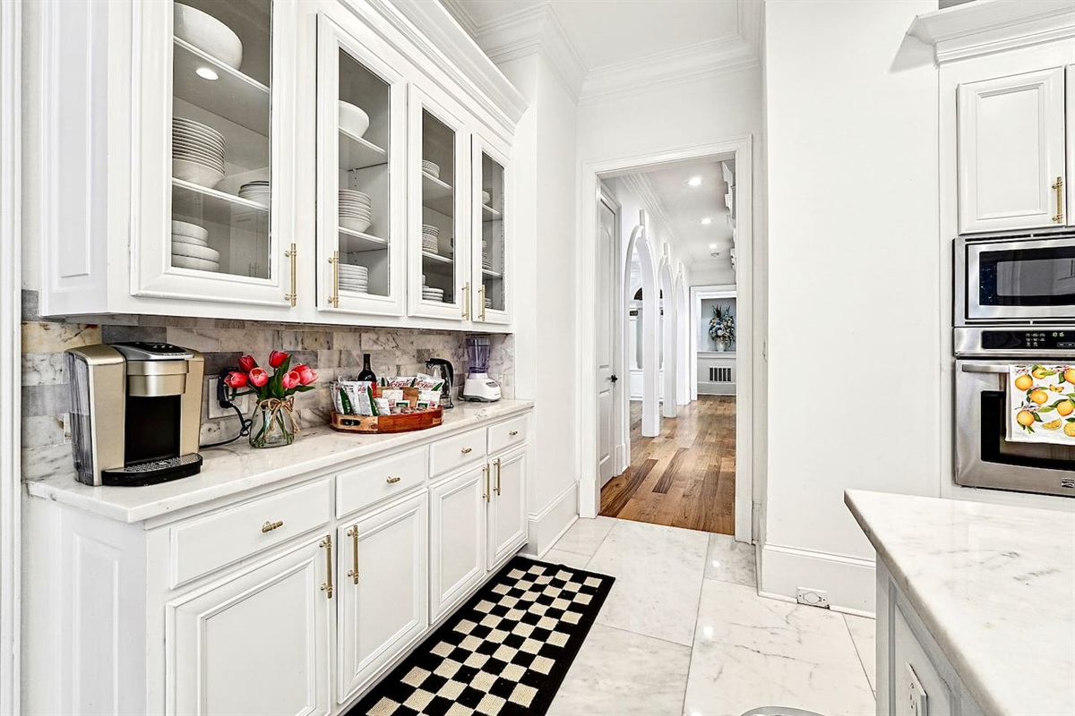 Bright and beautifully designed kitchen with white marble counters and white wood cabinetry. Fully equipped and ideal for cooking, gathering, and hosting with ease.