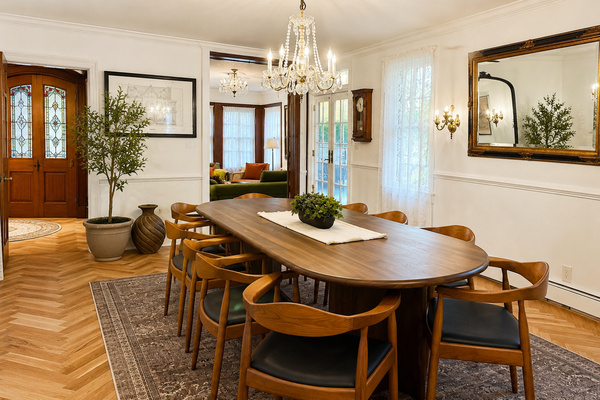 Elegant dining room with seating for 10 beneath the original crystal chandelier.