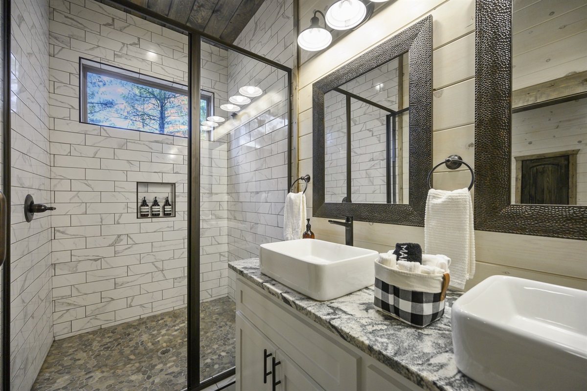A bright, clean bathroom with double vanities and modern finishes — perfect for freshening up after a day of forest adventures.