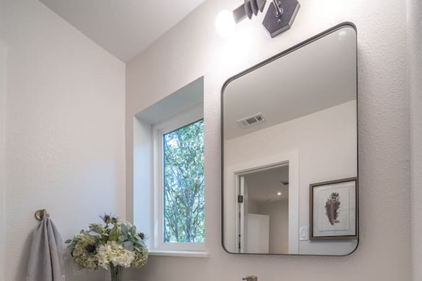 The ensuite bathroom for Bedroom 2 features a marble-topped vanity, modern fixtures, and soft lighting that enhances the clean, timeless finishes. 