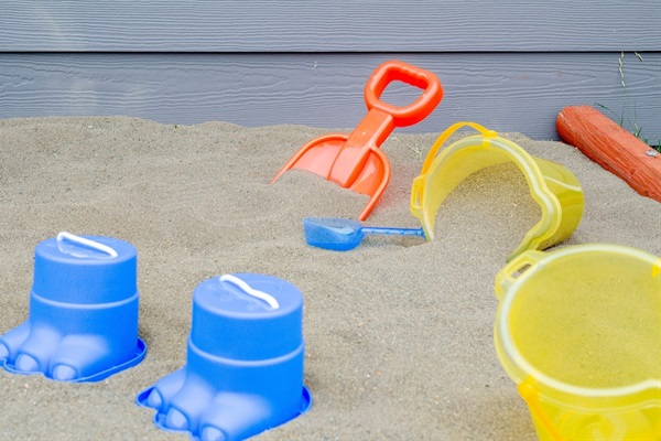 Backyard has an adorable sand box with toys for play.