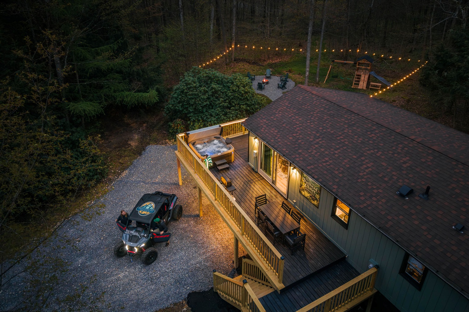 🌲 Your private hideaway glowing at golden hour — a cabin tucked into 2.5 forested acres at the top of Denton Hill. *(The UTV shown is not included — rent one from our partners at Denton Go, 5 min away; rental info is sent to every guest after booking.)*