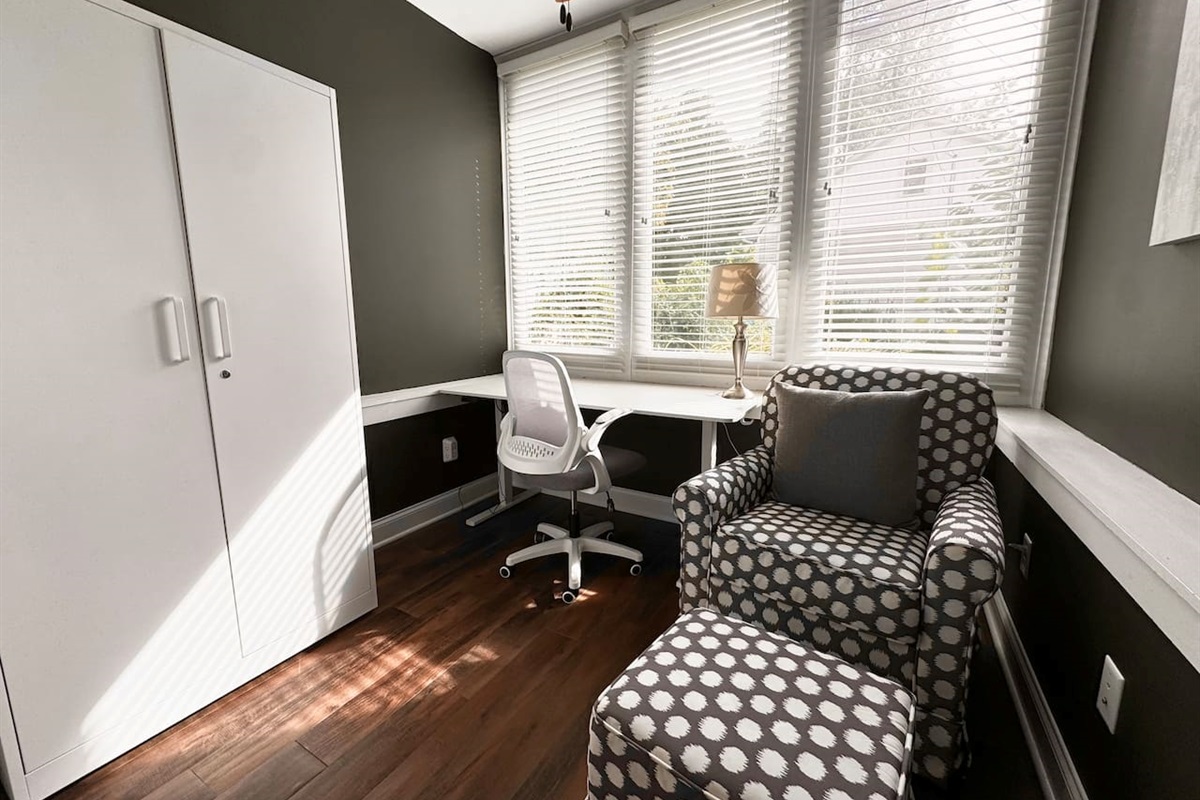 The sunny Garden Level Office includes an electric standing desk and rocking chair.
