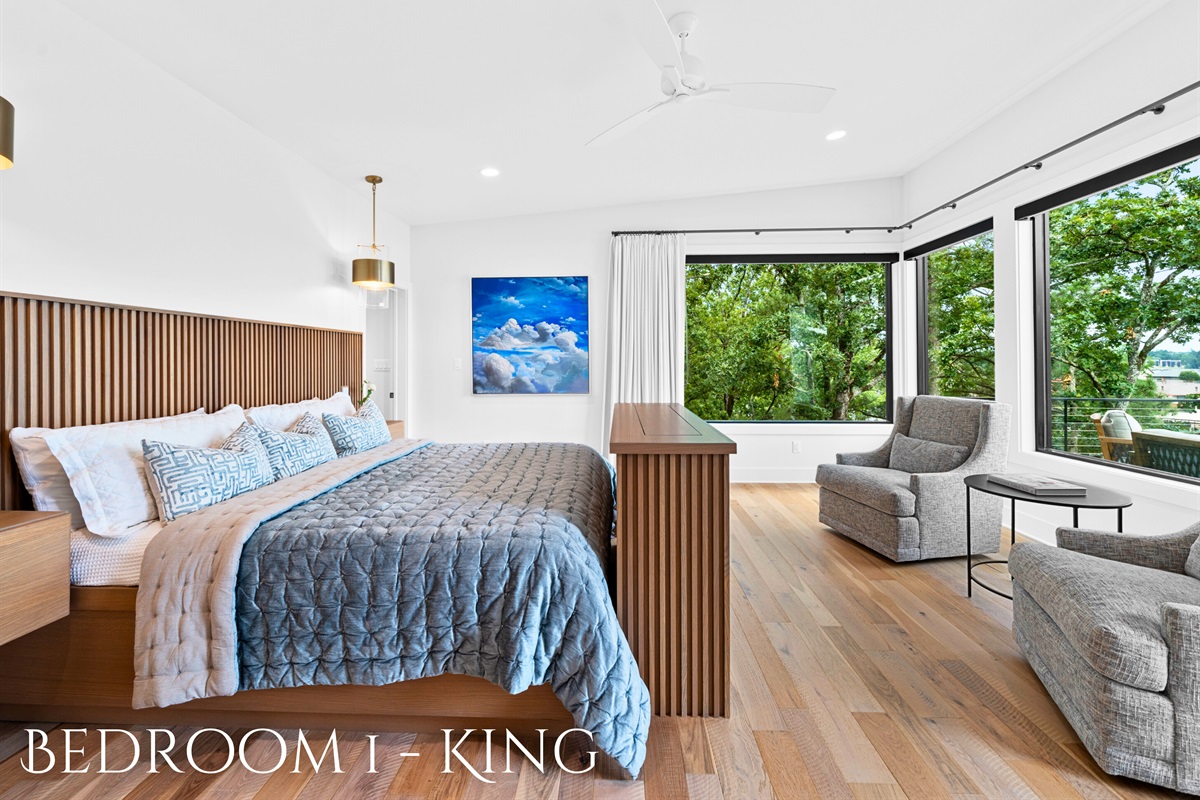 Enjoy the luxurious comfort of this king bedroom, complete with expansive windows and elegant furnishings.