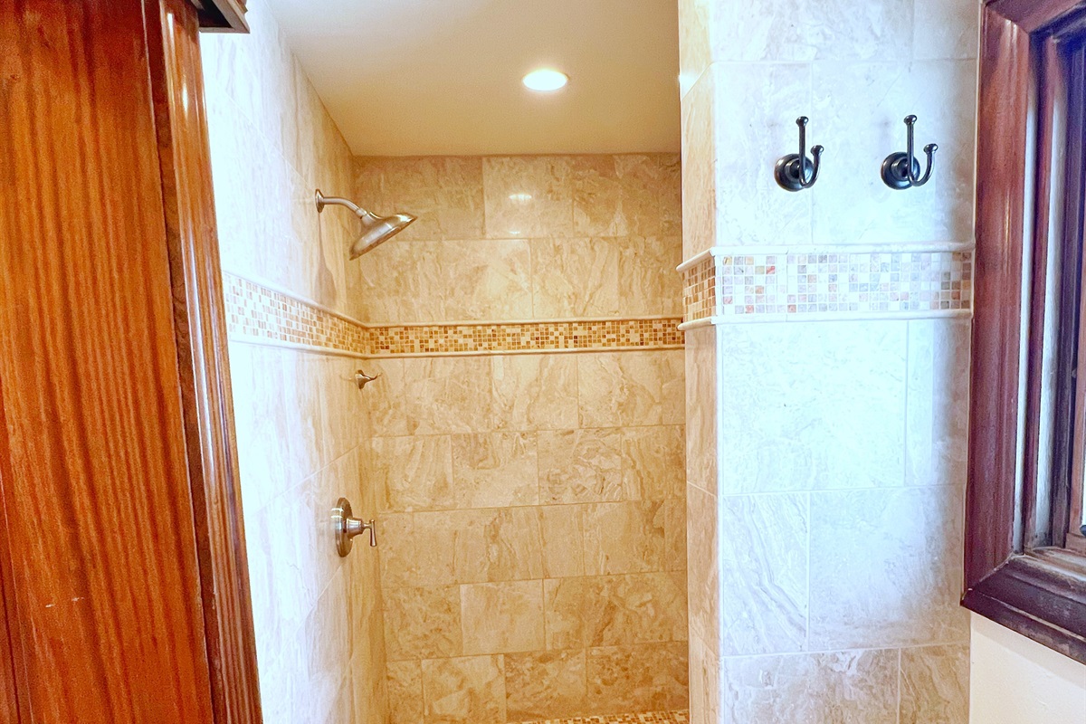 Stone tiling and a glass shower makes the bathroom a standout.