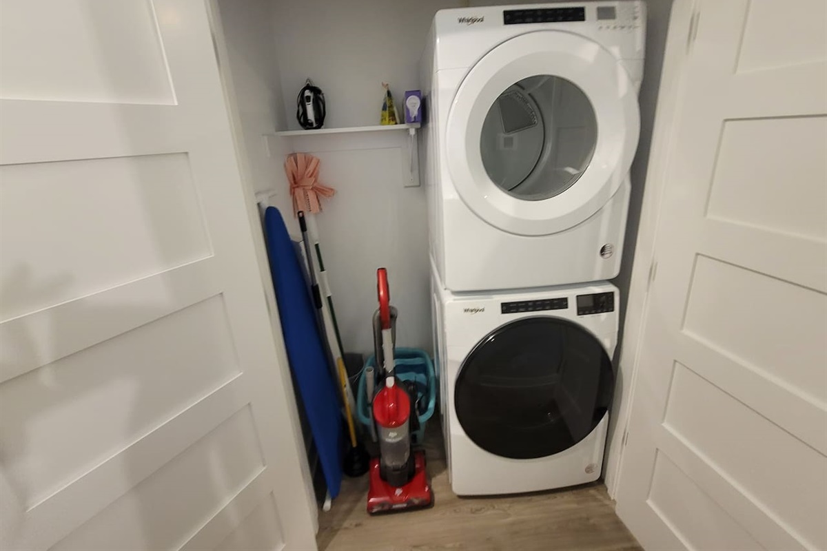 Full-size washer and dryer, ironing board and iron, vacuum, broom and laundry basket.