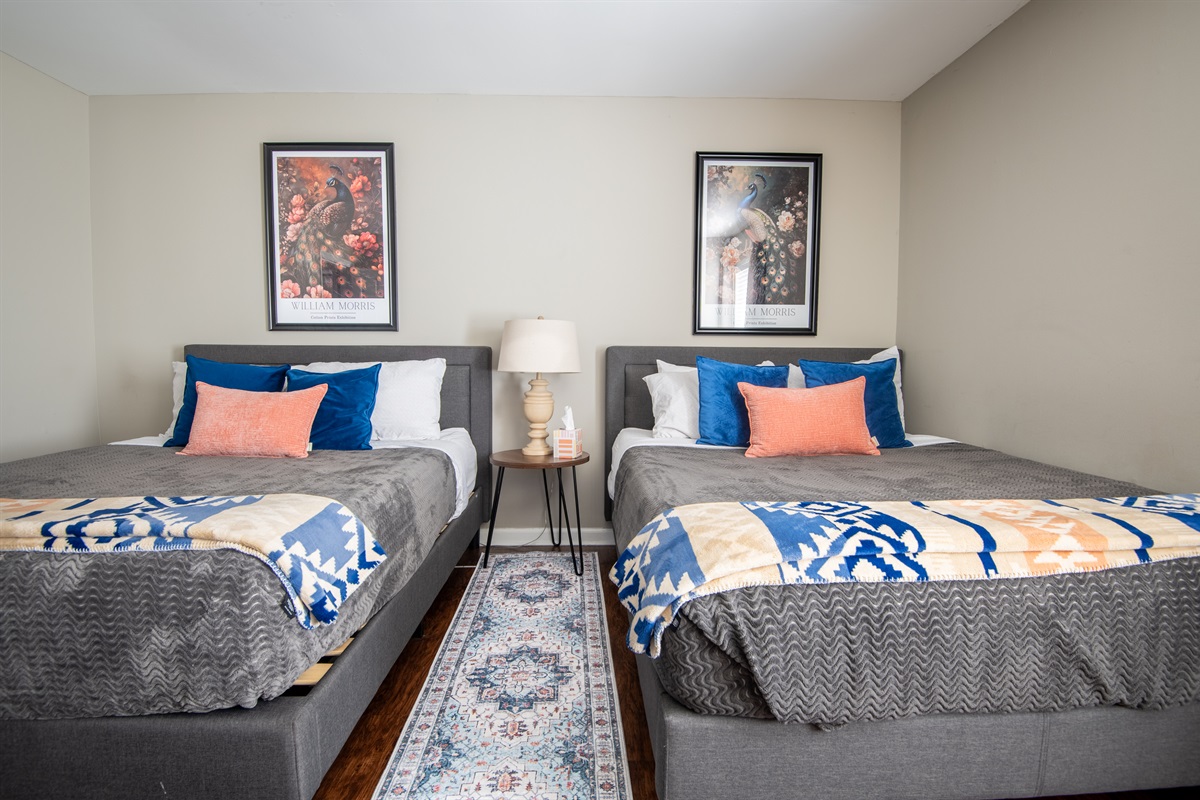 The double queen bedroom on the left in Unit B is thoughtfully designed for coziness and the best streaming nights!