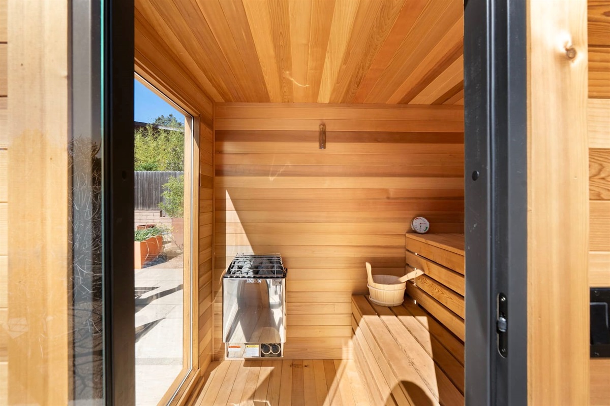 Beautiful cedar-lined sauna with bench seating and a traditional heater — a private, spa-like space designed for ultimate relaxation and rejuvenation.