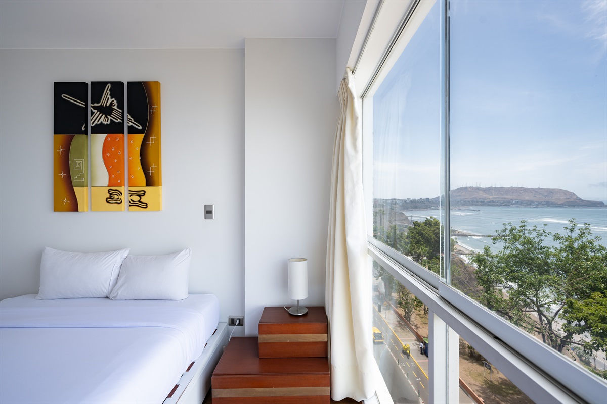 Modern comfort with a queen bed and unforgettable views of the ocean and Malecón  /  Cama queen y vistas inolvidables al océano y al malecón