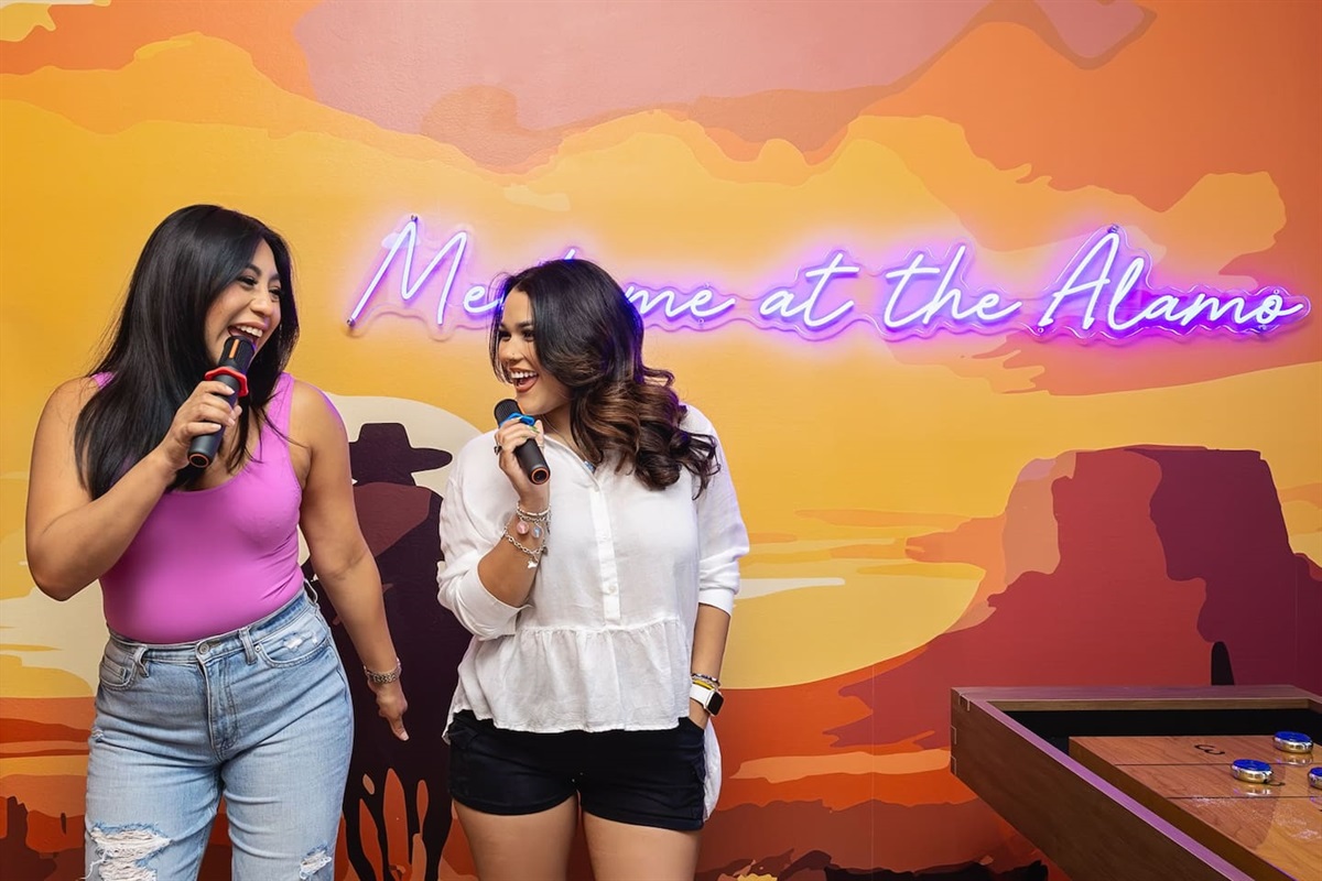 Let loose with your friends in this vibrant karaoke spot! Sing together under the "Meet me at the Alamo" sign, making memories, sharing laughs, and having an unforgettable time. Perfect for friends seeking a fun, music-filled night!