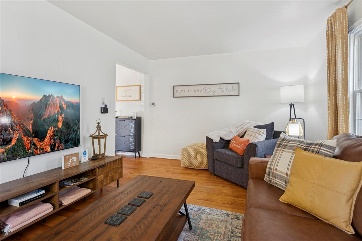 Comfort meets charm—our South Bend guest retreat living room features plush seating, cozy blankets, pillows, coasters, and a smart TV. A perfect spot to relax near Notre Dame.