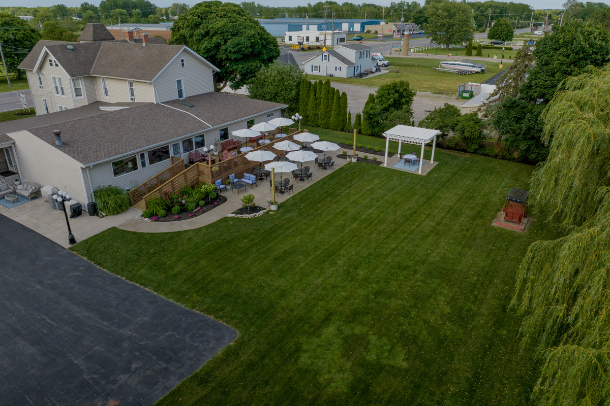 Our outdoor oasis features multiple patios, a romantic garden swing, blooming roses, pergola seating, and plenty of space to unwind during your Marblehead getaway