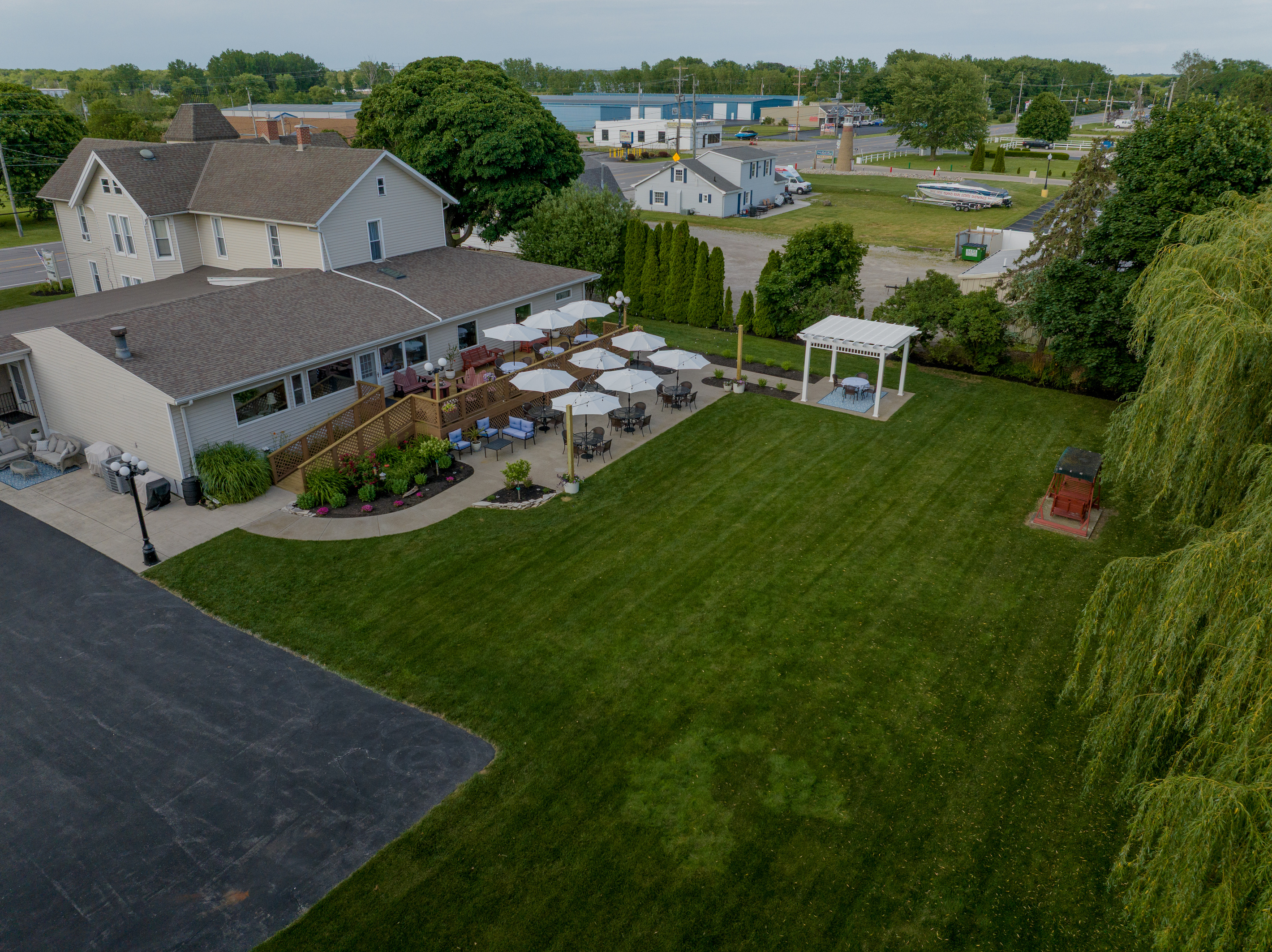 Our outdoor oasis features multiple patios, a romantic garden swing, blooming roses, pergola seating, and plenty of space to unwind during your Marblehead getaway