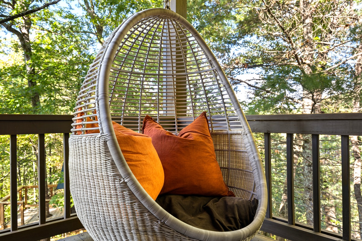 Swing into serenity... the egg chair cradles you in forest calm.