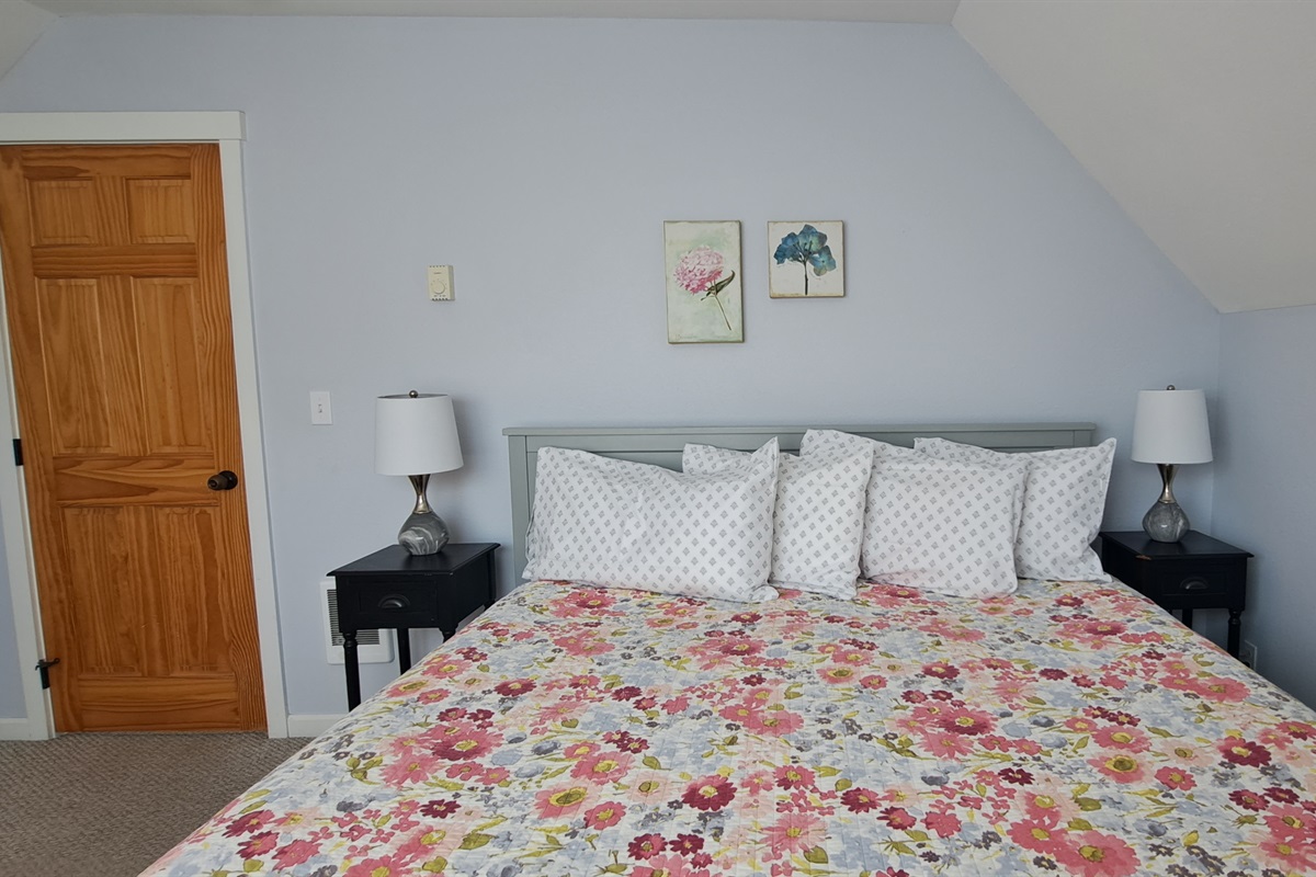 Soft pastel accents complete the king bedroom, offering a peaceful and inviting space to unwind after a day at the beach.