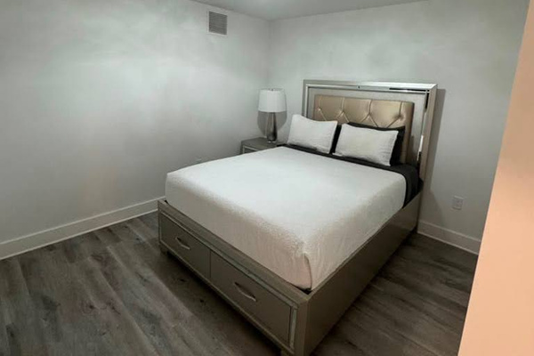 Interior bedroom, no window.   TV mounted on the wall.