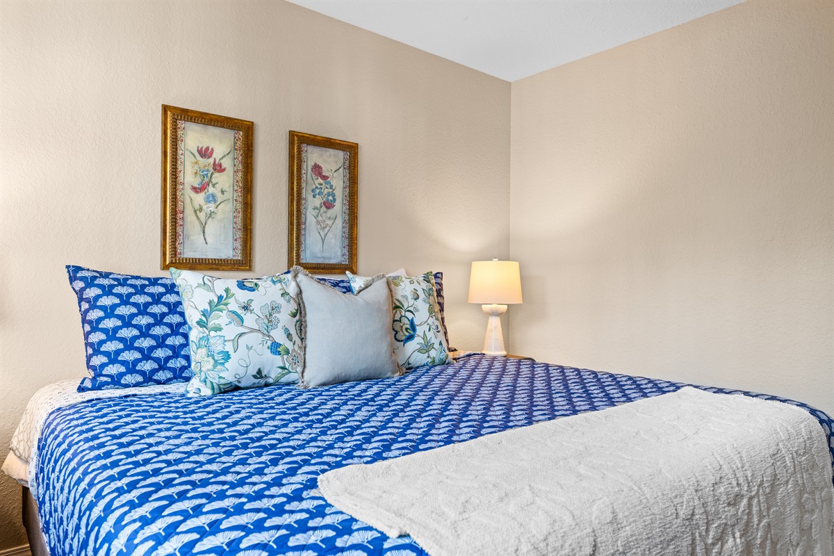 🛏 Relax in the bright and inviting guest bedroom, featuring a plush king bed, layered pillows, and charming botanical artwork.