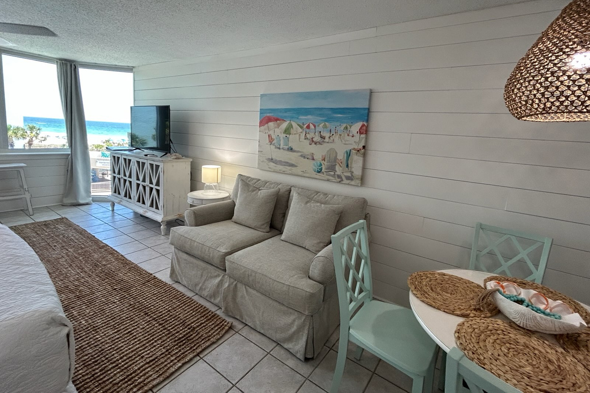 Relax in the comfortable living area with a loveseat, smart TV, dining table, and beautiful Gulf views just steps from the beach.