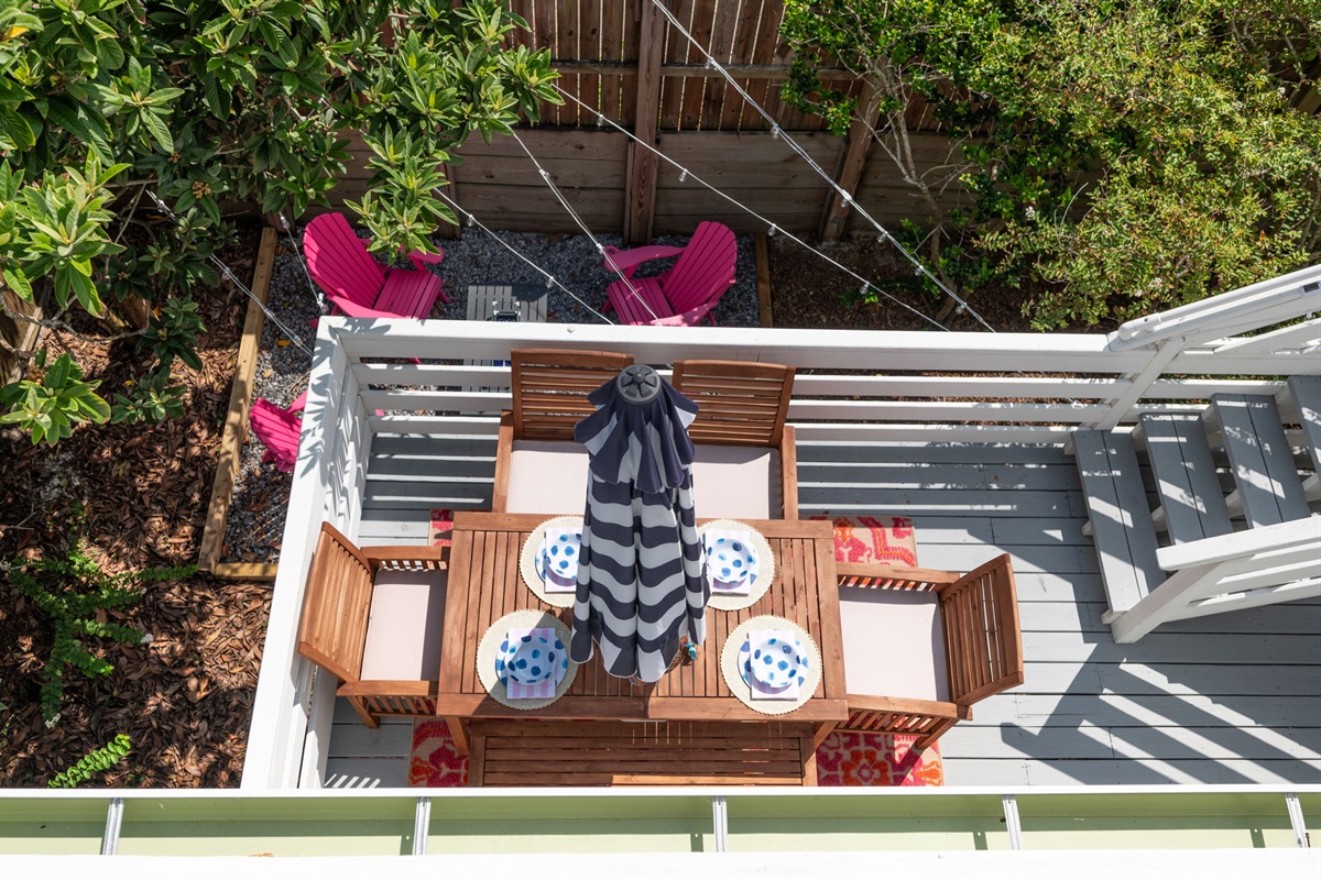 This picture, taken from the Eagle's Nest, looks down on the deck where you can see the outdoor dining table on the second-story deck, and the cozy backyard with its inviting firepit. A perfect blend of outdoor living spaces for relaxation and entertaining