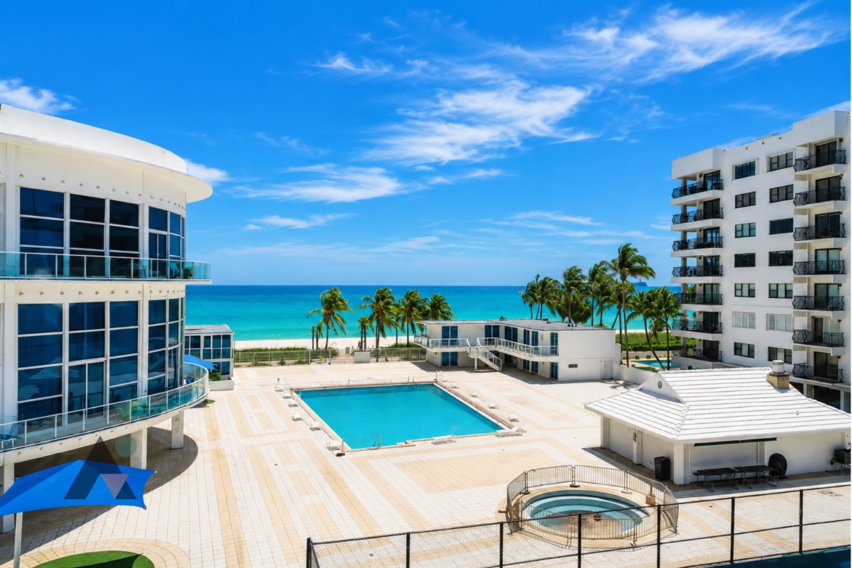 The oceanfront pool and sun deck sit right above the beach, open daily from 9 AM to sunset.