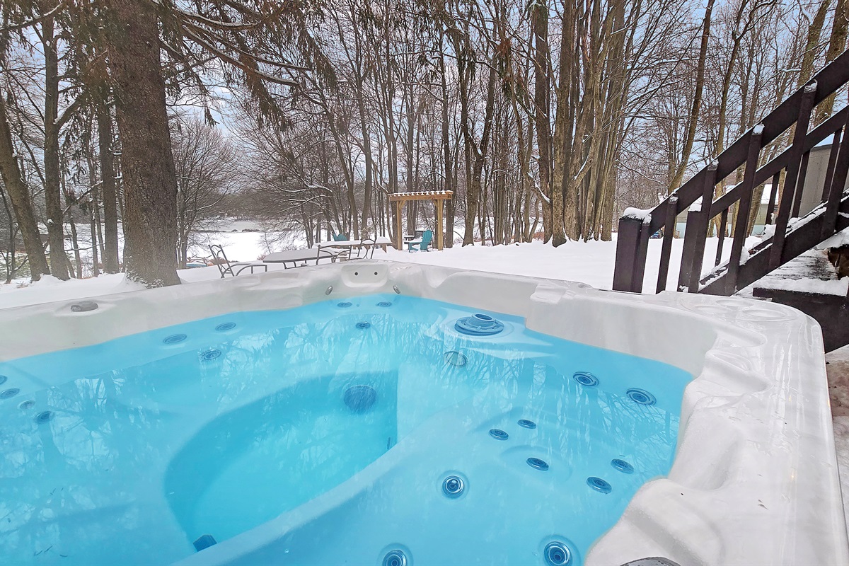 Soak in the steaming hot tub while taking in the snowy backyard views!