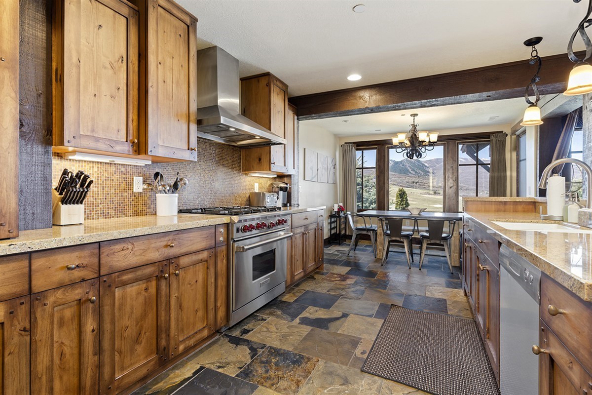 A chef-caliber kitchen featuring premium appliances, rich wood cabinetry, and generous prep space along with mountain views—designed to inspire both everyday meals and gourmet creations.