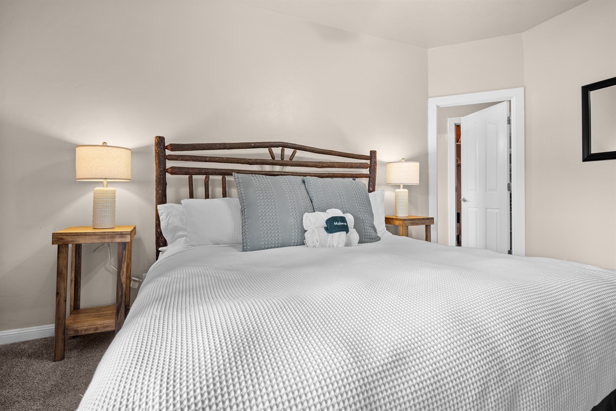 The primary bedroom suite boasts a luxurious king-sized bed and ample storage space.