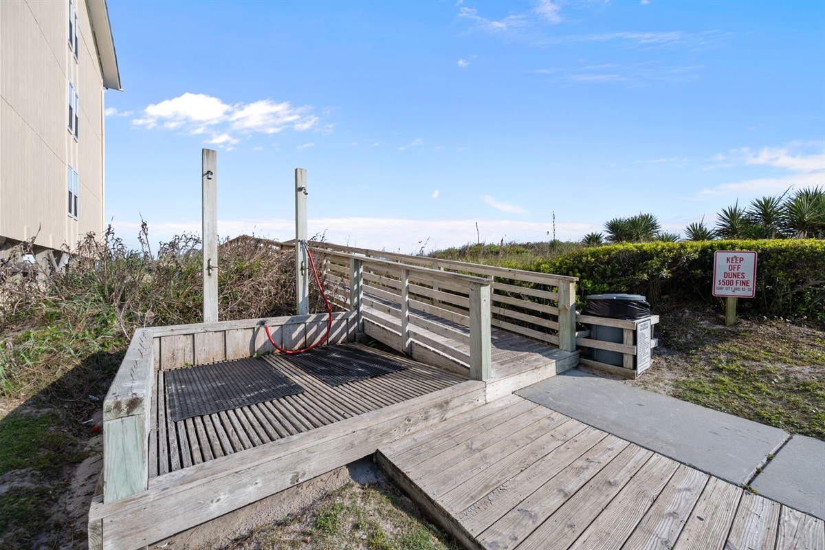 Easy-access boardwalk leading directly toward the shoreline with convenient outdoor shower