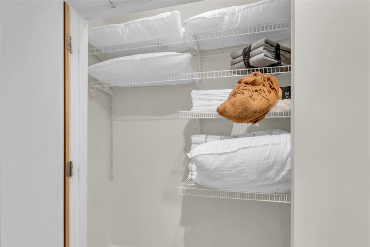Storage closet stocked with extra pillows and blankets, providing added comfort and flexibility throughout your stay.
