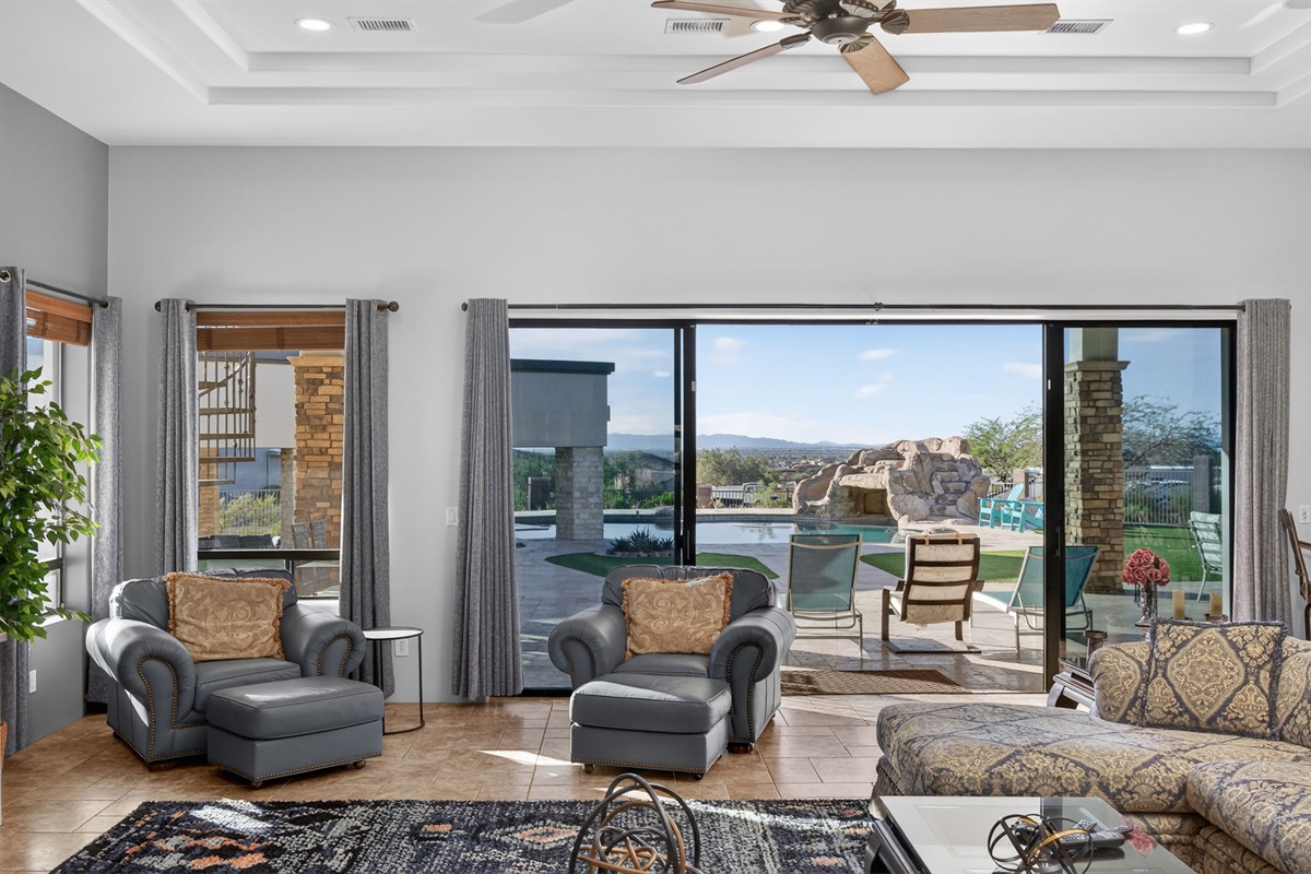 Wall-to-wall sliding glass doors frame resort-style backyard views and bring natural desert light into the main living space