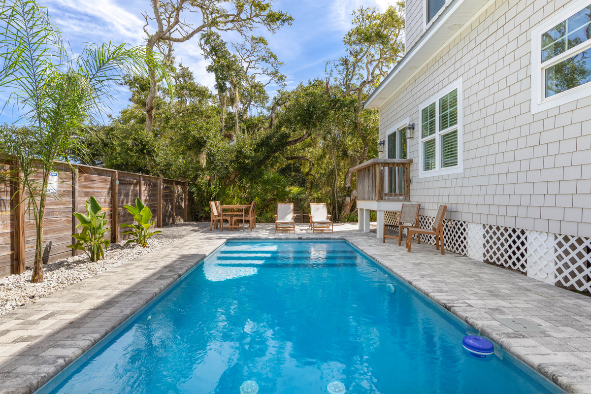 Swim a length and you are back at the steps. The house sits right there behind you - close enough that someone can call down from the deck that the burgers are on without anybody having to leave the water.