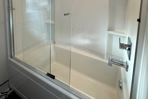 Full bathroom at the end of the hallway with an updated medicine cabinet/mirror, new elongated oval toilet, and tub/shower combo.