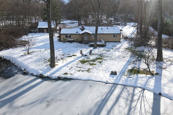 Backyard drone shot of house & pond.