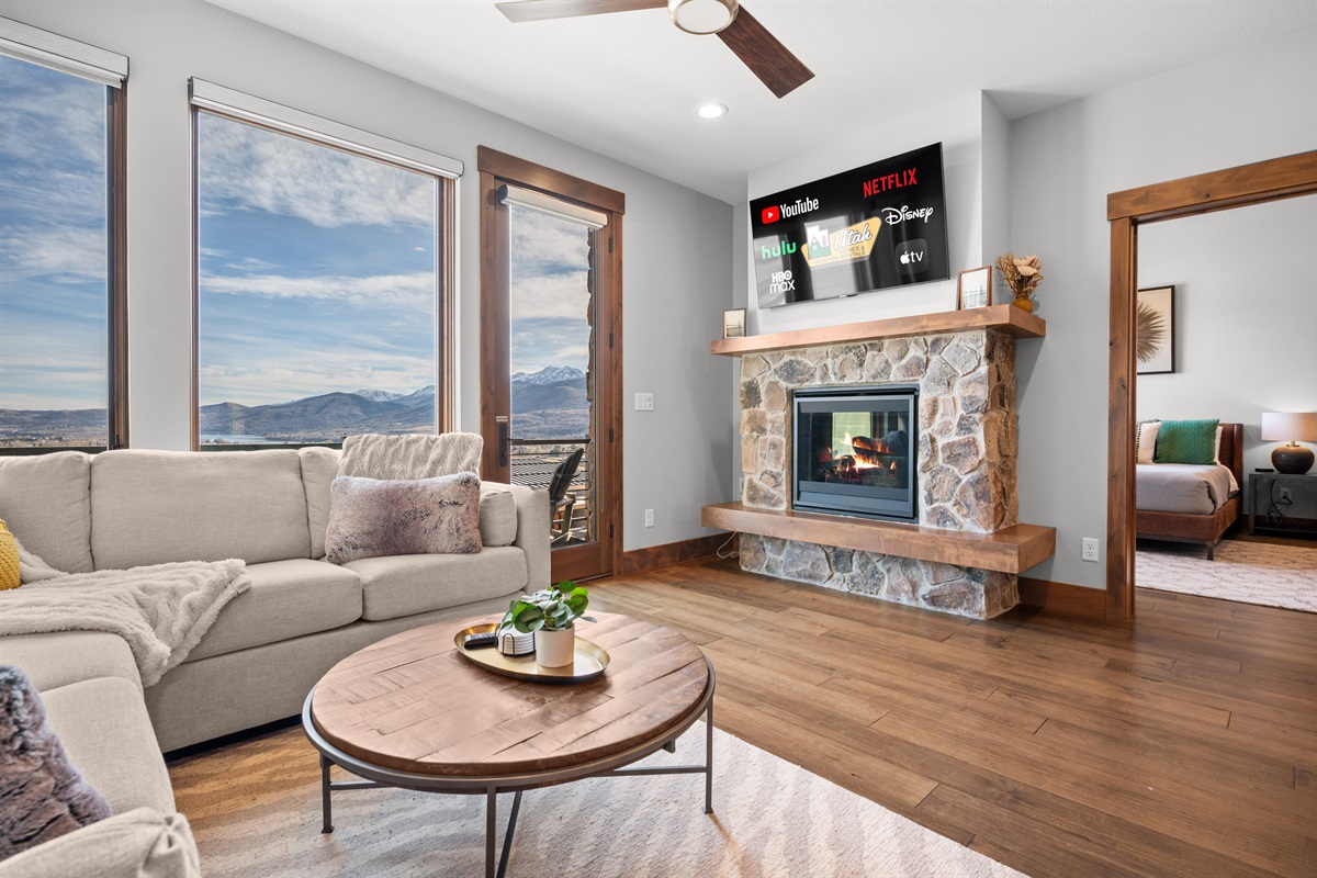 Cozy fireplace and large windows showcasing stunning mountain scenery