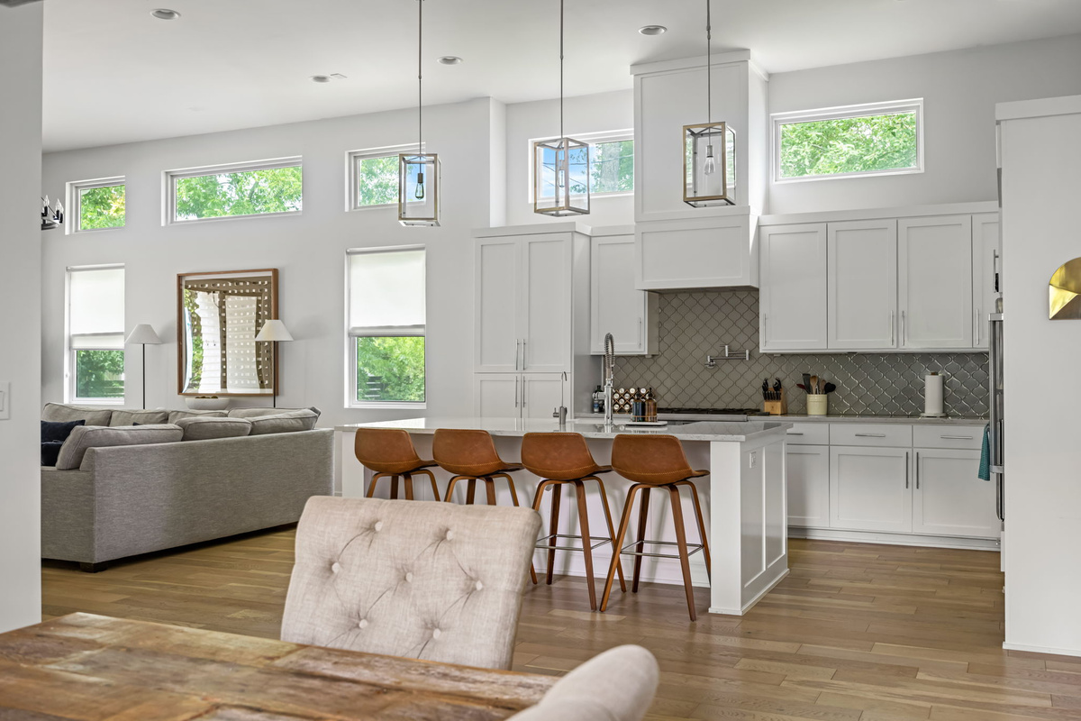 Spacious kitchen island with bar seating overlooking a cozy living room — the perfect hub for gathering while staying connected.