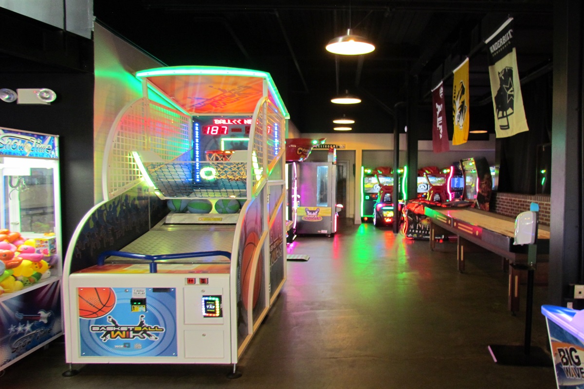 Unleash your inner gamer at the Village Hideaway's vibrant arcade, featuring a wide array of classic and modern games including basketball, shuffleboard, and more, for endless family fun.