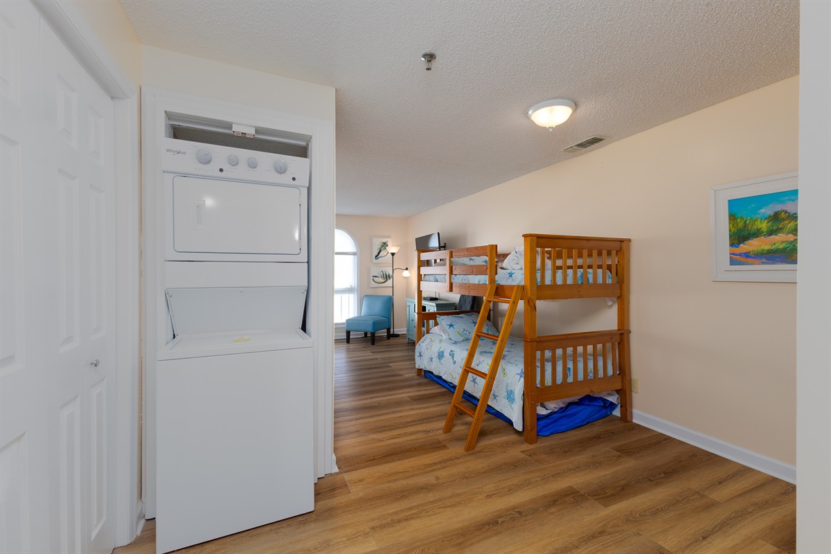 A compact stackable laundry unit is conveniently located near the entrance of bedroom 3