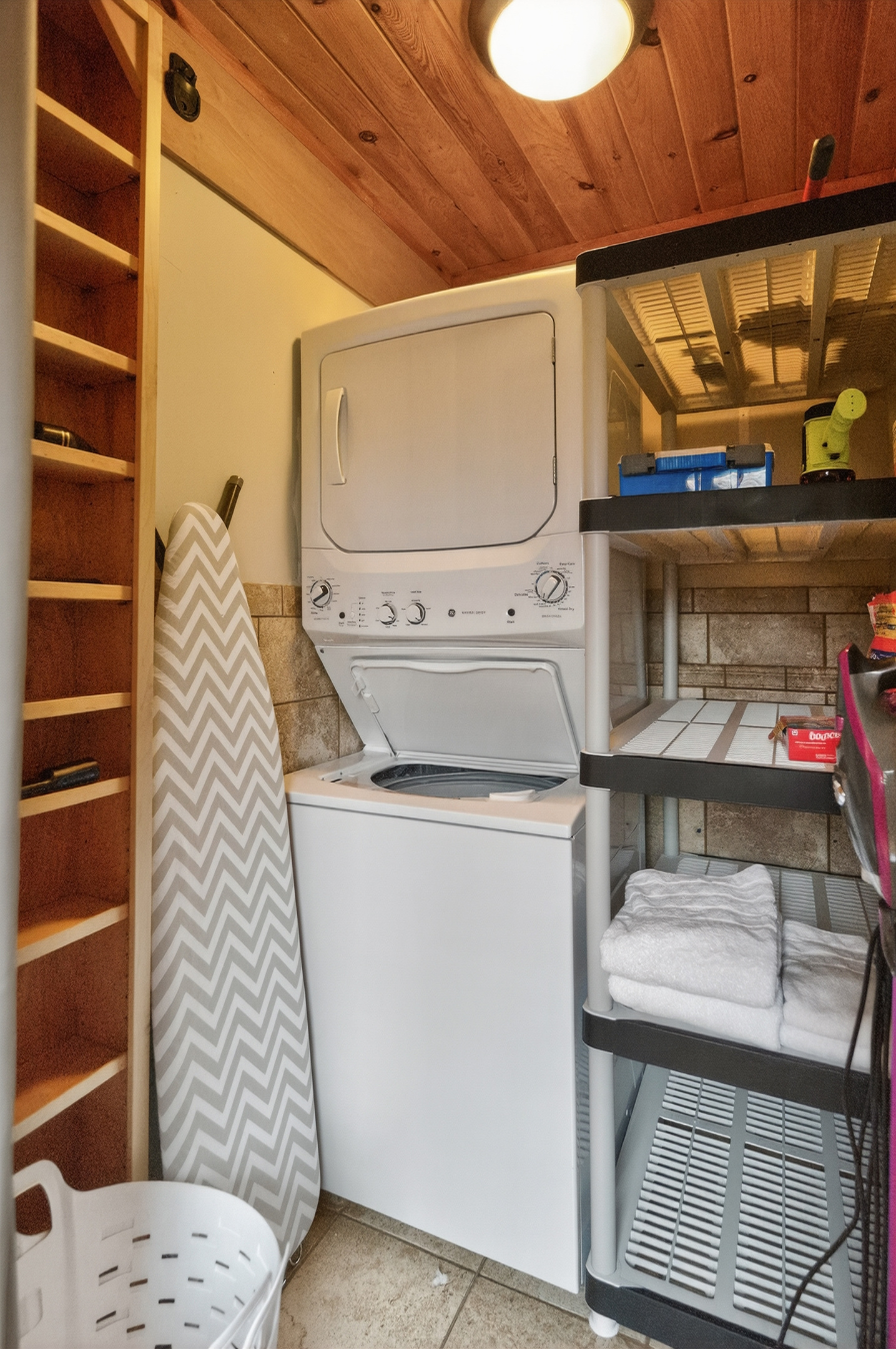 Laundry area with dryer and shelves for folded linens