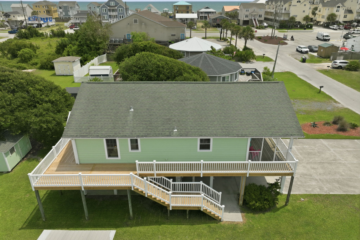 Aerial view showing the home's proximity to the beach and surrounding coastal neighborhood