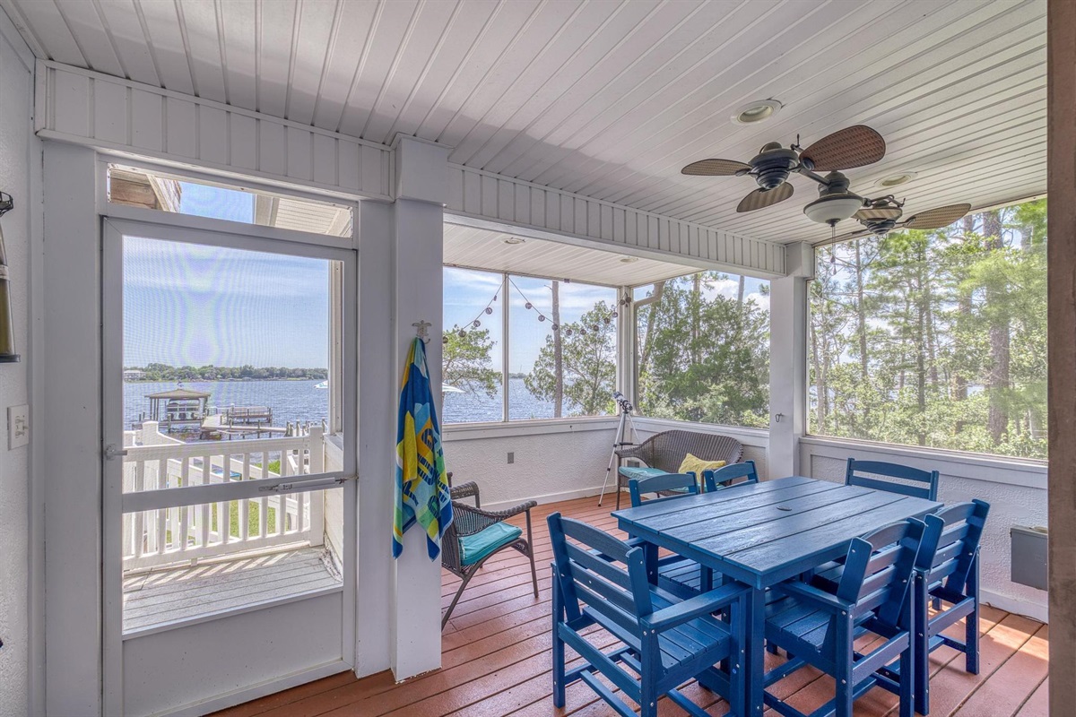 Screened patio with dining table. 