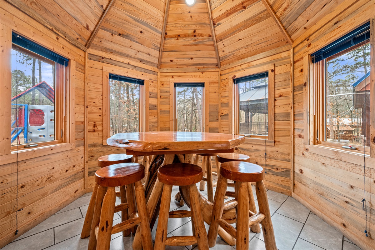 Framed by windows, the dining area feels bright and inviting while still offering peaceful views of the surrounding trees.