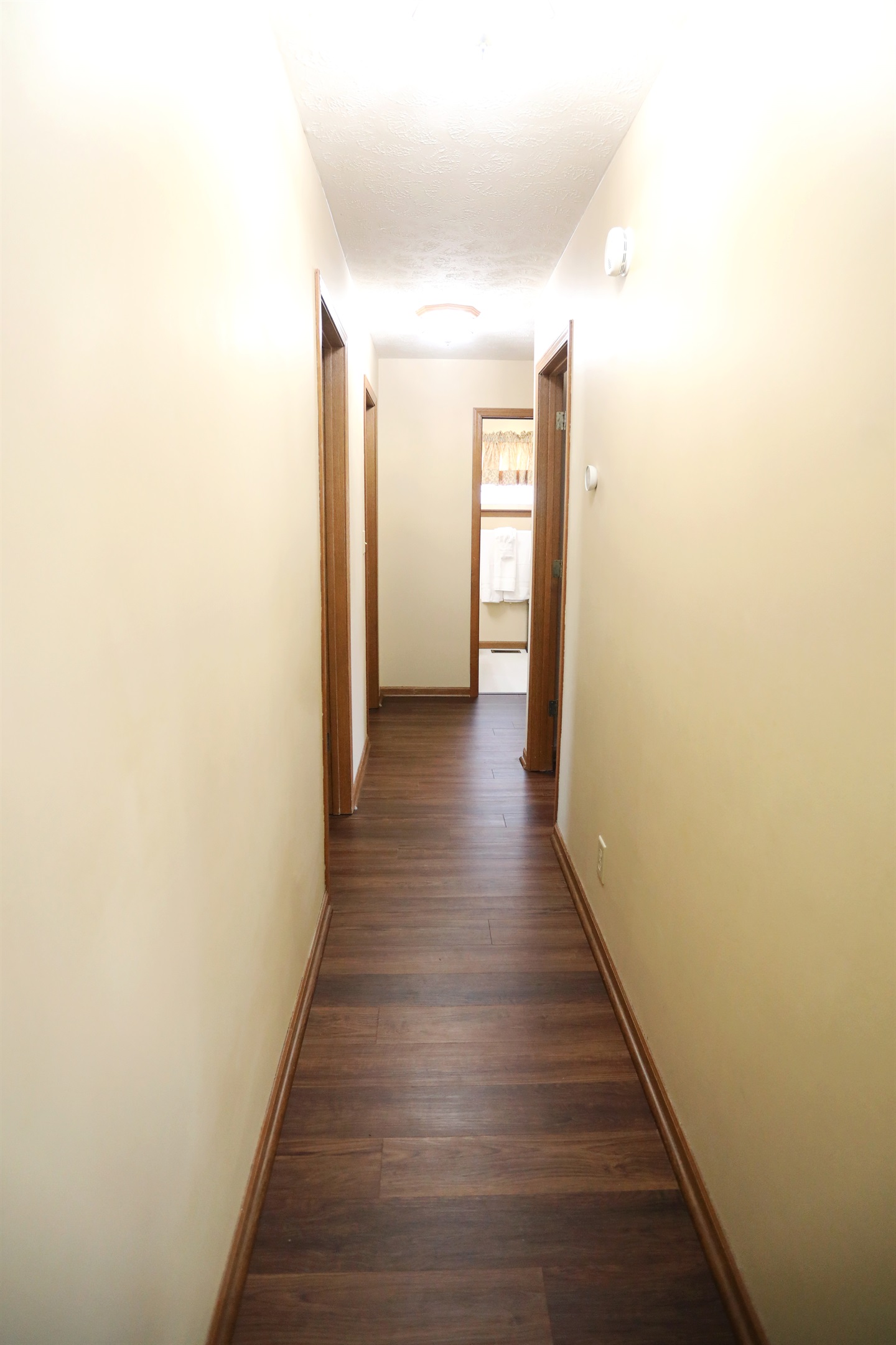 Hallway showing two bedrooms to the left, master suite to the right and second full bathroom straight ahead